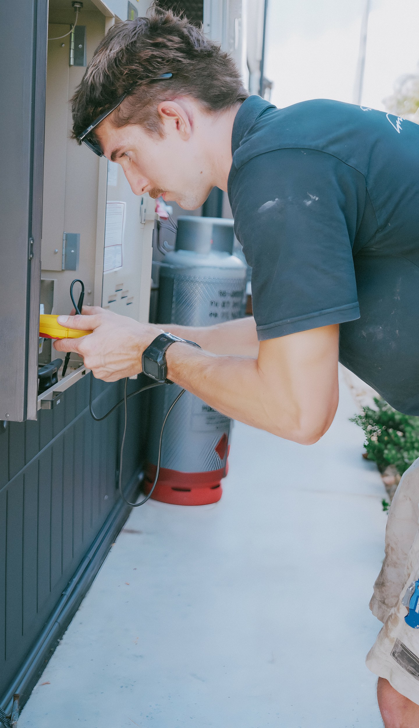 Electrician installing a new power point at a Gold Coast home