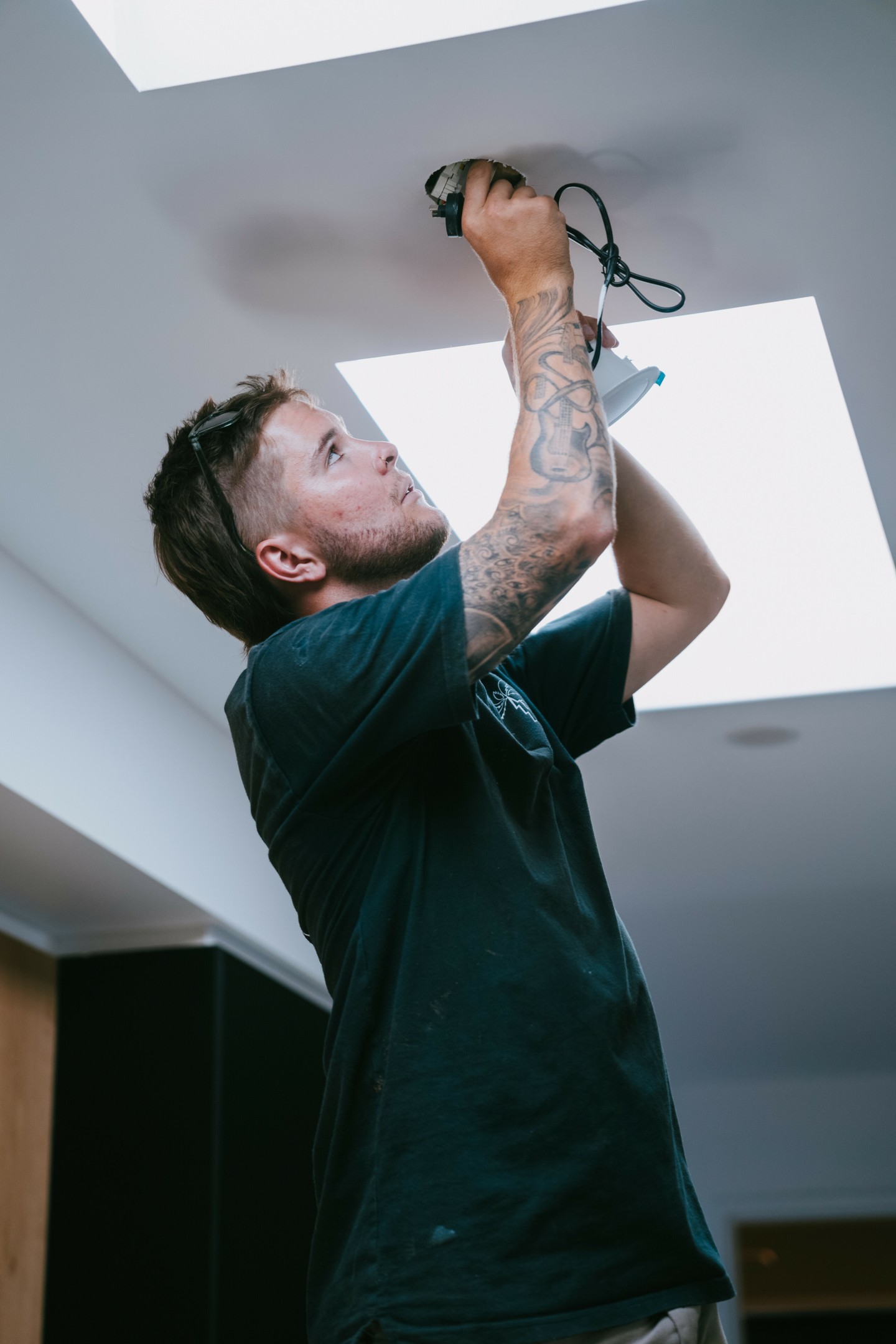 Electrician installing LED downlights in a Gold Coast home
