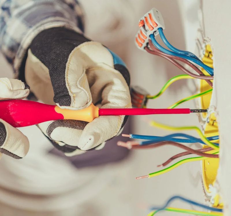 Electrician rewiring a switchboard during an upgrade