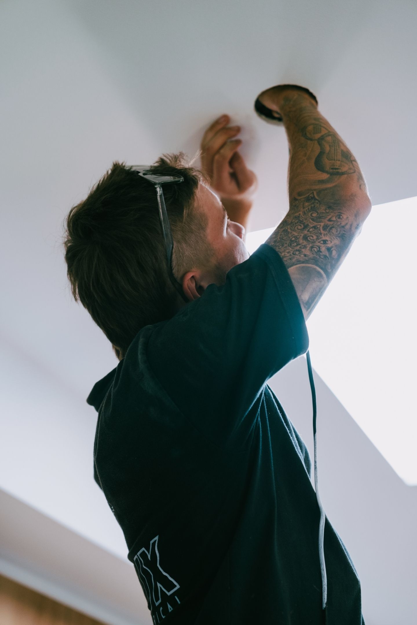 HUX electrician installing a ceiling light fitting